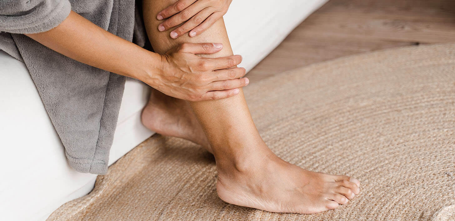 Kobieta trzymająca się za nogę