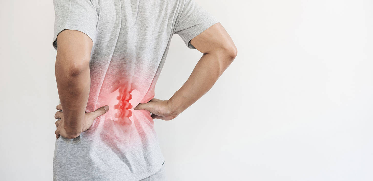 Widok męskich pleców od tyłu z podświetlonym kolorem czerwonym dolnym odcinkiem kregosłupa