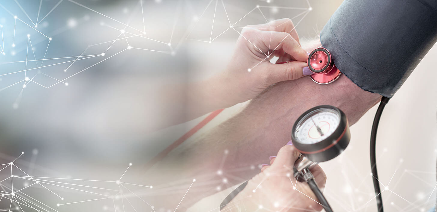 Kobiece ręce mierzące ciśnienie mężczyźnie za pomoca ręcznego aparatu do mierzenia ciśnienia